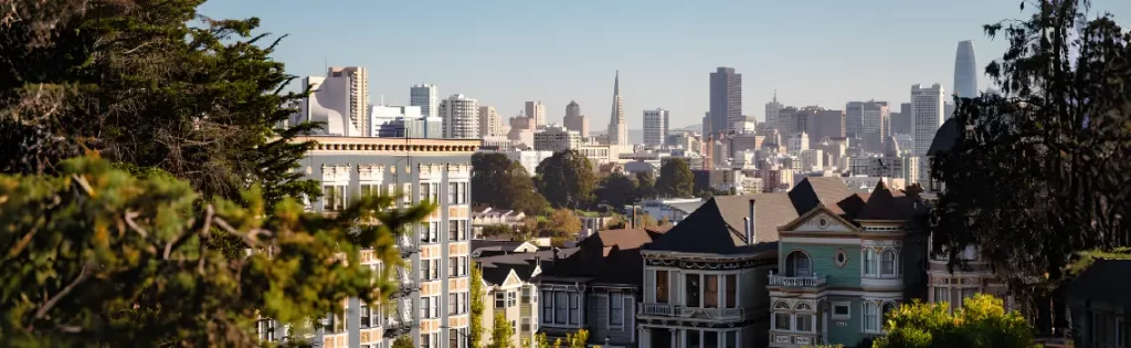 Panoramic view of a cityscape with residential buildings in the foreground, a dense collection of various other buildings .